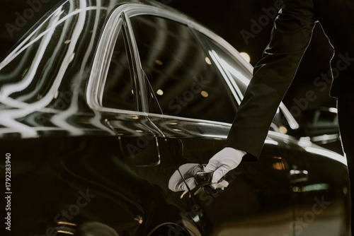 Obraz na plátně Caucasian middle aged man wearing glove opening car door, only arm and hand visi