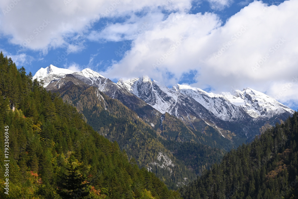 Fototapeta premium snow mountain under blue sky with white clouds in sunny afternoon