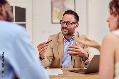 Professional Insurance Agent Discusses Plans With Young Couple In A Modern Office Setting