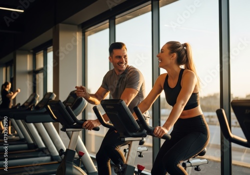 Happy couple working out together on stationary bikes at the gym