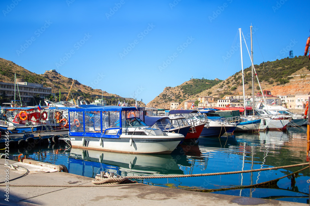 Obraz premium A view of yachts and boats in the bay between the mountains. Picturesque bay with fishing and pleasure boats