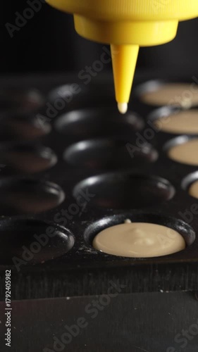 Unknown man chef preparing round pancakes on a hot surface
