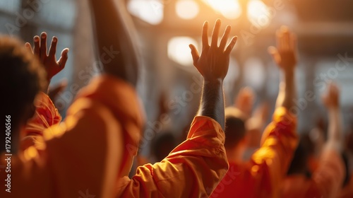 Group of students in orange jumpsuits raising hands in a sunlit classroom, expressing eagerness and participation