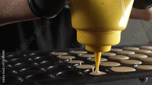 Unknown man chef preparing round pancakes on a hot surface