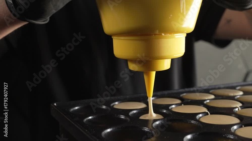 Unknown man chef preparing round pancakes on a hot surface