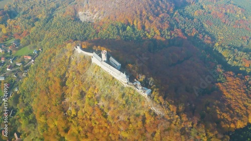Experience the breathtaking beauty of Bezdez Medieval Castle during an enchanting autumn sunrise. The landscape is adorned with vibrant fall colors, showcasing nature's splendor.