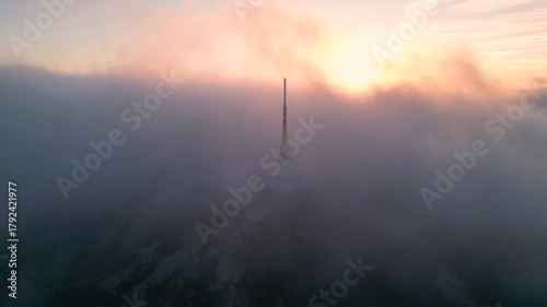 Watch as Jested Mountain disappears into the clouds during a stunning sunset in Liberec, Czechia. This serene moment captures nature's beauty and tranquility.