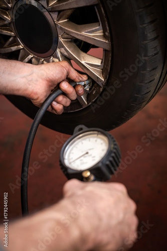 Wallpaper Mural Mechanic checking tire pressure using a gauge Torontodigital.ca