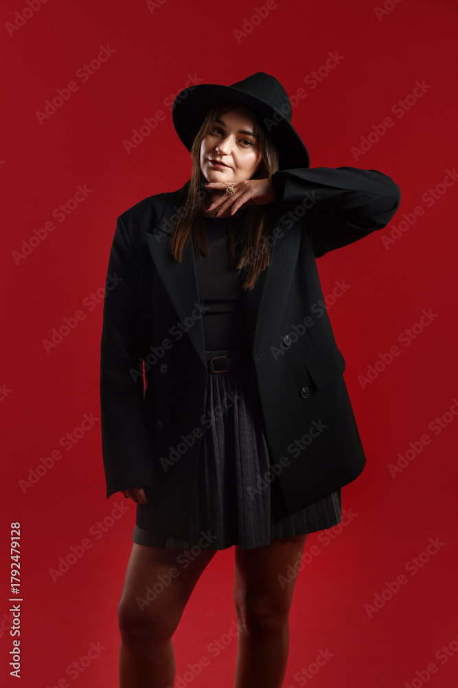 Fototapeta premium Beautiful young woman in stylish clothes posing on red background