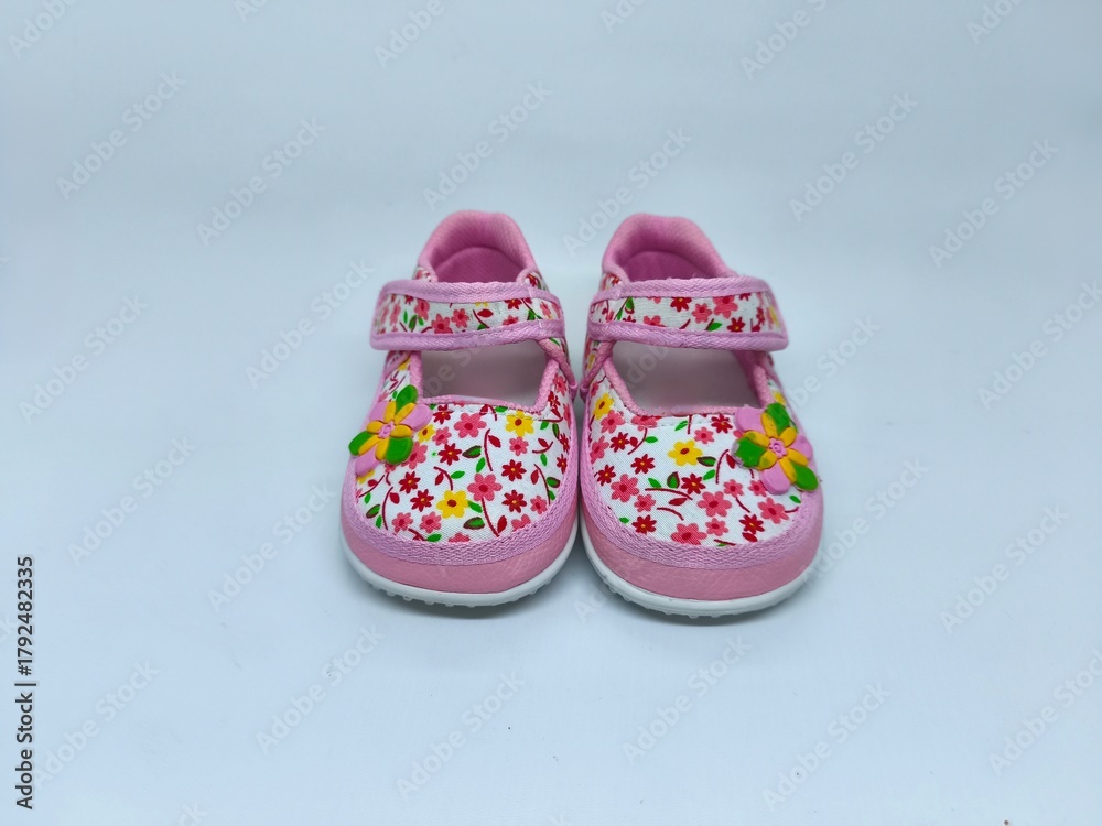 Fototapeta premium Adorable Pink Baby Shoes with Floral Pattern on White Background