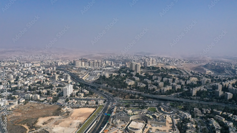 Fototapeta premium Northern Jerusalem aerial viewA wide drone shot overlooking northern Jerusalem with residential neighborhoods, highways, and distant desert hills on the horizon.