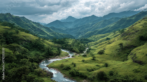Aerial view of a river flowing through a lush green mountain valley area
