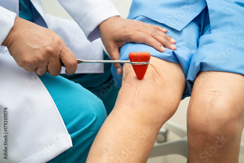 Fotografía Asian doctor knock on knee reflex nerve for check and treatment senior patient in hospital