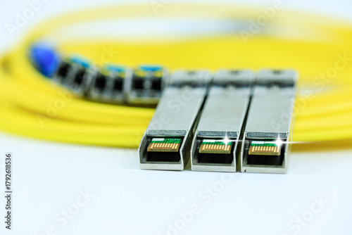 Photography Yellow coiled fiber optic patch cord with blue connectors SFP modules are essential for high-speed data transmission over fiber optic networks
