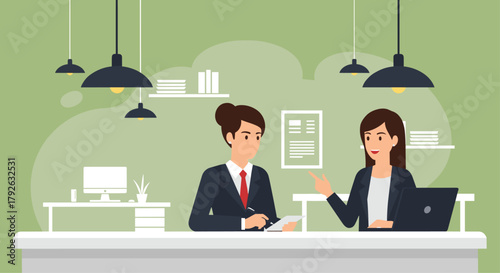 Two professional women collaborate on a project, discussing ideas at a modern office desk with laptops and paperwork