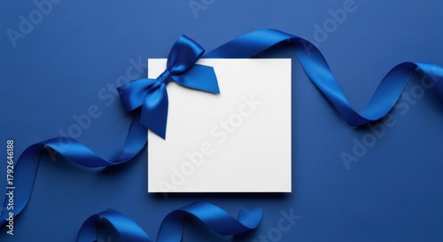 Blank card tied with blue ribbon and bow on a blue background