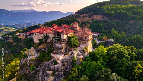Ancient structure perched on cliff, surrounded by green trees and mountains
