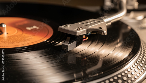 Close-up of a stylus on a spinning vinyl record. Vintage turntable tonearm playing music on an LP. Analog audio equipment and retro nostalgia concept