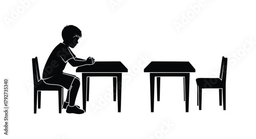A silhouette of a young student sitting at a desk in a classroom