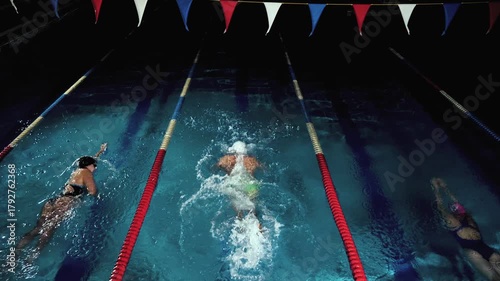Competitive Swimmers Training in Dark Pool, Butterfly Freestyle and Breaststroke