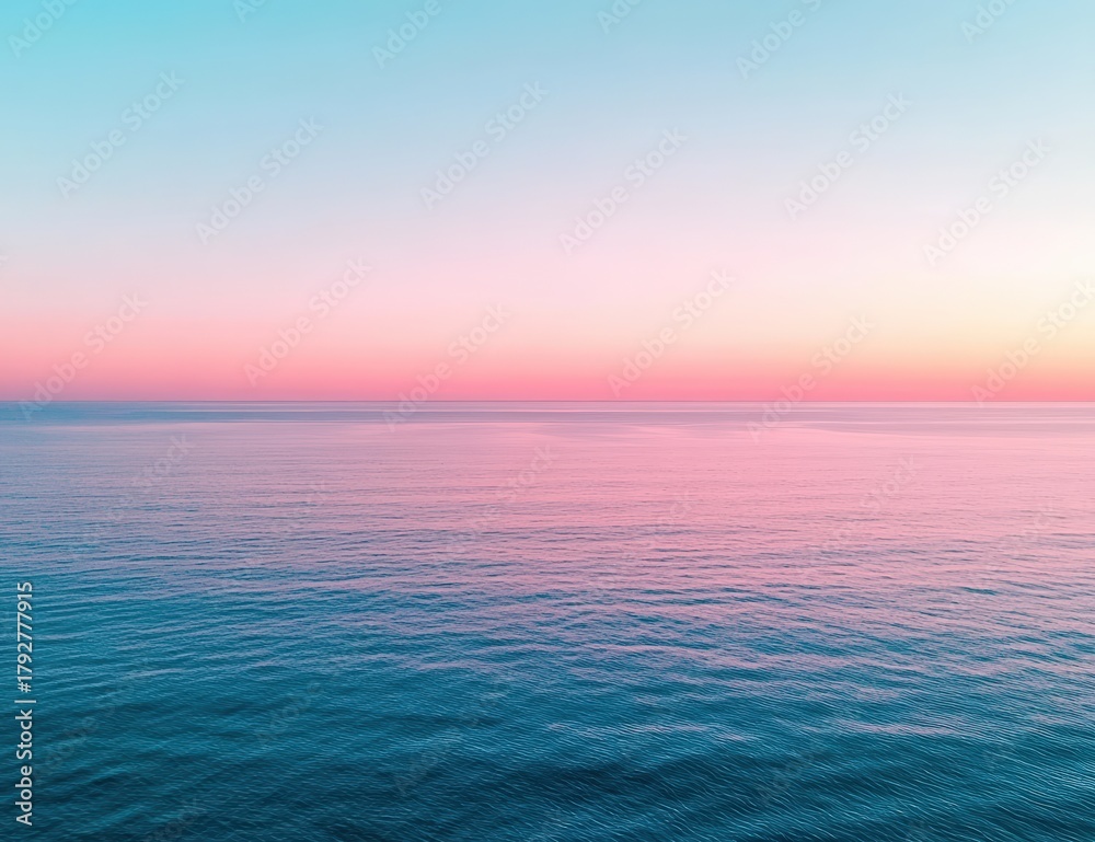 Obraz premium A serene ocean view at sunset, showcasing a gradient of soft pink and blue hues across the sky and water.