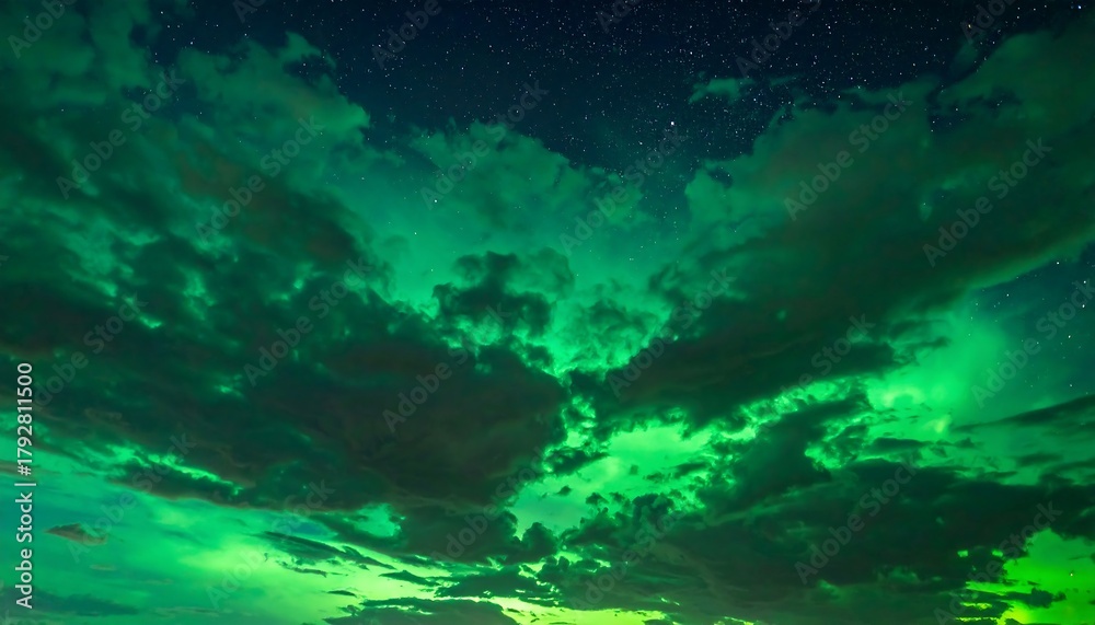 Fototapeta premium Green, ethereal light bursts through the dark clouds under a night sky speckled with stars in this dreamy image