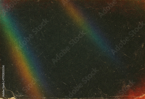 Vintage textured background featuring two soft rainbow arcs across a dark grainy surface, creating nostalgic retro vibes, moody atmosphere, light leaks, and artistic color spill