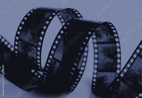 Fotografija Blue grainy film reel winding through retro motion picture strip with sprocket h