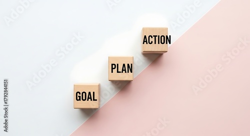 Wooden blocks display goal plan and action on a pink white surface