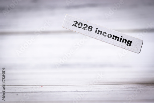 Handwritten wooden sign displays the message 2026 incoming, implying anticipation for the upcoming year. This visual can be used for planning and future events.