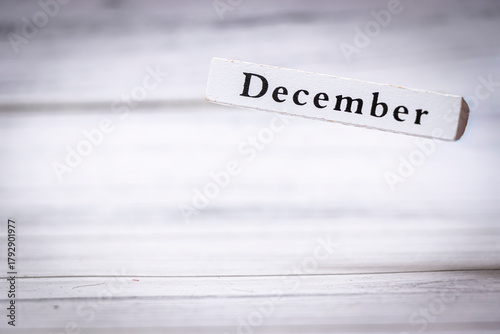 Handwritten text on a wooden sign displaying December, representing the last month of the year. Symbolizes winter festivities and year-end reflections.