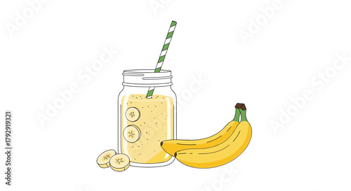 Freshly made banana smoothie sits in a glass jar with a green striped straw, garnished with banana slices next to a whole banana.
