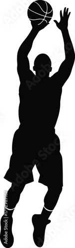 Silhouette of a basketball player in mid air shooting a ball