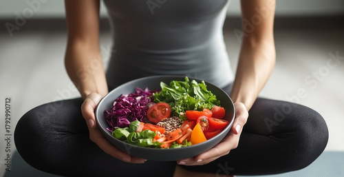 Healthy lifestyle concept – woman in sportswear holding fresh vegetable salad