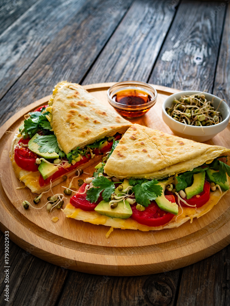 Obraz premium Healthy breakfast - italian piada wraps with scrambled eggs, tomatoes, avocado, coriander and bean sprouts