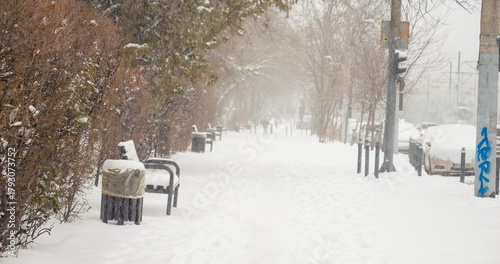 Cuadro en lienzo Snow falls heavily over the city, covering streets and pathways, making travel difficult