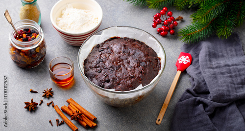 Christmas pudding in glass baking dish. Traditional festive dessert. Grey background. Close up.