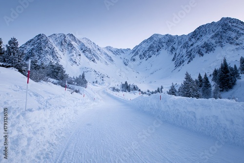 Wide-angle view of a snowy biathlon competition trail in the mountains