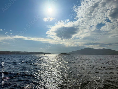 Sunlit Waters and Distant Mountains on a Clear Day