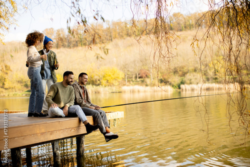 Quadro su tela Friends enjoying a fishing day by the calm lake during autumn