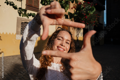 Woman framing view outdoors with hands smiling