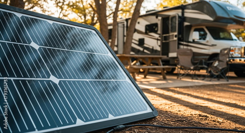 Portable solar panel charging a battery on a camper van. Alternative energy solution for outdoor adventure trip.