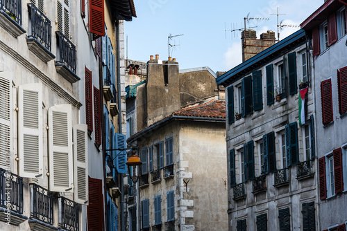 Charming white buildings with green shutters in the heart of Bayonne, France.