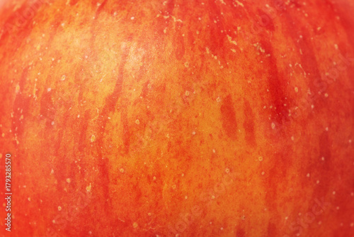 Texture of red apple with yellow color as background macro photo.