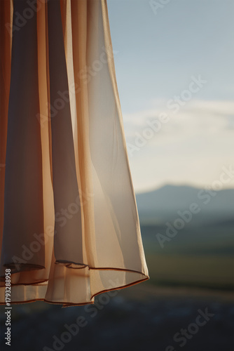 delicate fabric sways gracefully in gentle breeze illuminated by warm glow of sunset