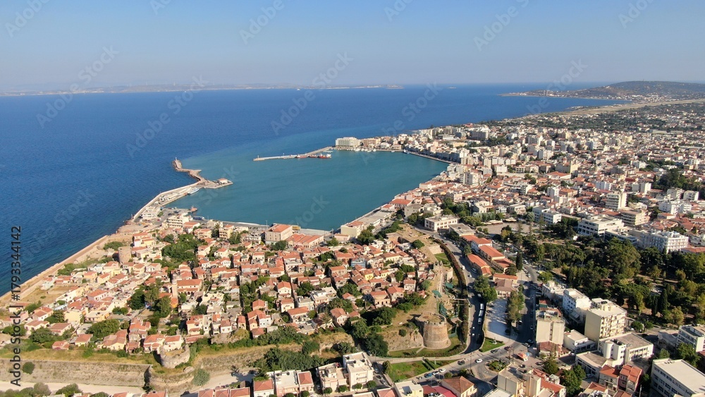 Naklejka premium Aerial drone view of the main port of Chios, Greece. Ferries, harbor infrastructure, waterfront urban landscape and clear Aegean waters. High-resolution Mediterranean maritime and travel photography.
