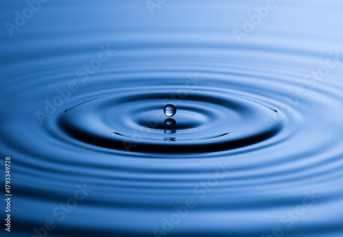 Blue Water drop falling, macro splash. Natural background