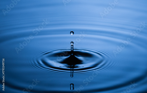 Blue Water drop falling, macro splash. Natural background