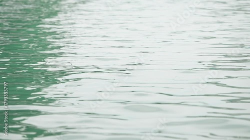 Slow motion showing gentle ripples on the lake surface at Ohori Park, Fukuoka, Japan, with sunlight reflections and soft blue tones evoking calmness and simplicity