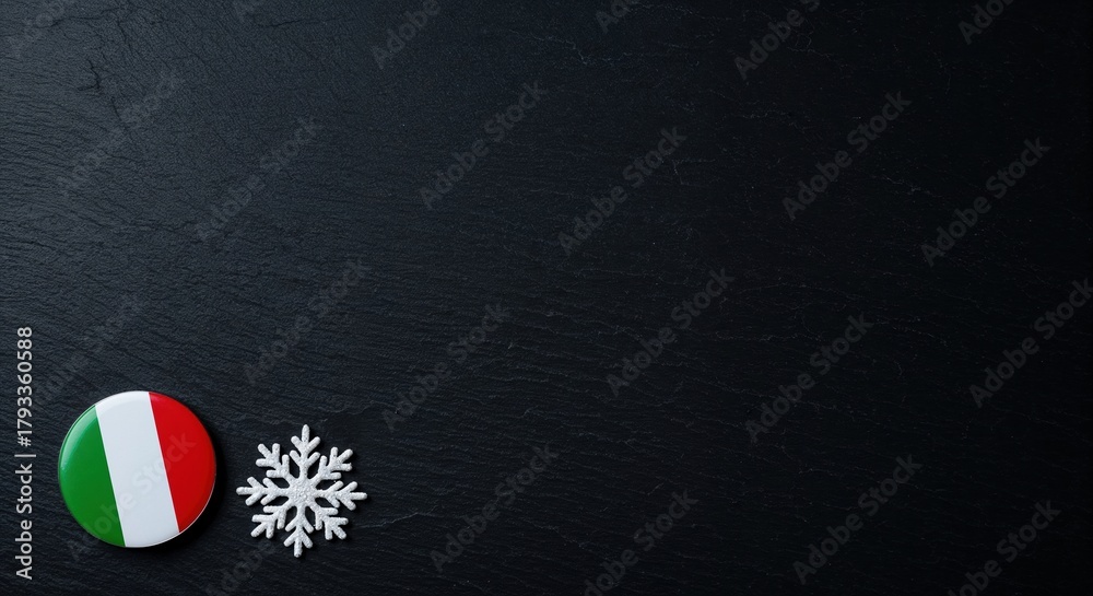 Naklejka premium A vibrant round Italian flag badge is placed beside a delicate white snowflake decoration on a dark, rough slate background, providing generous copy space.